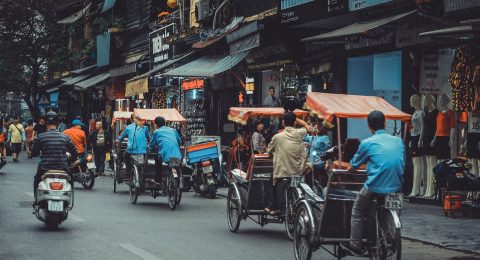 man driving white motor scooter on road