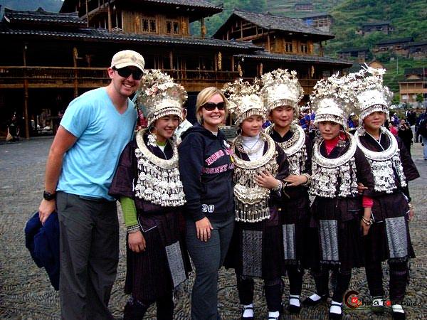 Dos turistas posan con chicas de Xijiang. 