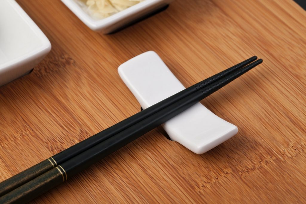 black pen beside white square plastic container on brown wooden table