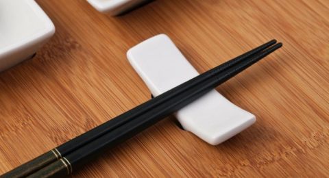 black pen beside white square plastic container on brown wooden table