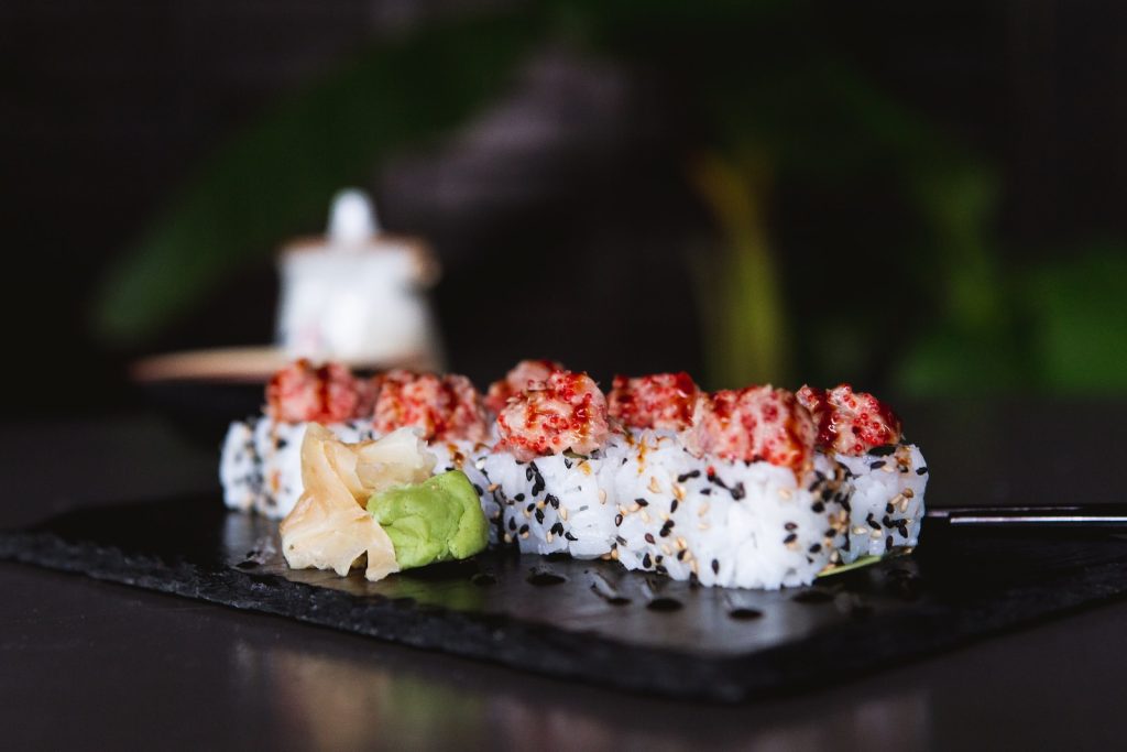 a piece of sushi on a black plate