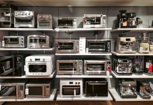 A bunch of microwaves that are on a shelf